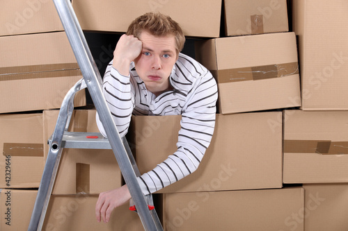 Photo: Man stuck behind stacks of cardboard boxes Man stuck behind stacks of cardboard boxes