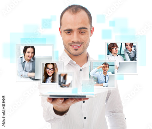 Photo: Adult businessman using his tablet computer to communicate his t Adult businessman using his tablet computer to communicate his t