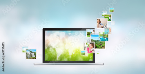 Photo: Open laptop at blue background. Pictures are flying out of the s Open laptop at blue background. Pictures are flying out of the s
