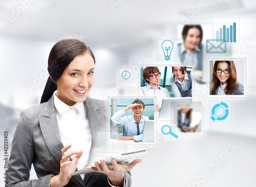 Photo: Portrait of businesswoman holding her tablet computer and commun Portrait of businesswoman holding her tablet computer and commun