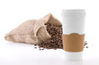 Disposable cup of coffee over sack of coffee beans