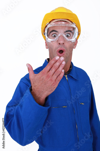 Foto: Shocked manual worker wearing safety glasses Shocked manual worker wearing safety glasses