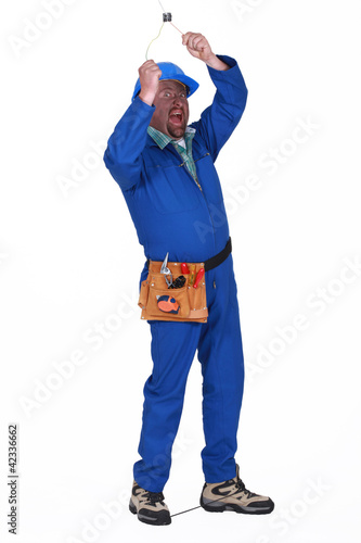 Photo: Man touching live electrical wire Man touching live electrical wire