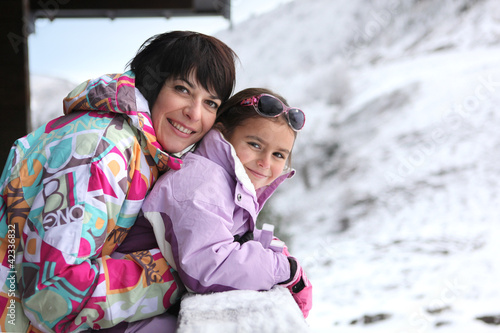 Foto: Mother and daughter stood by chalet Mother and daughter stood by chalet