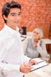 Young waiter taking an order in a restaurant