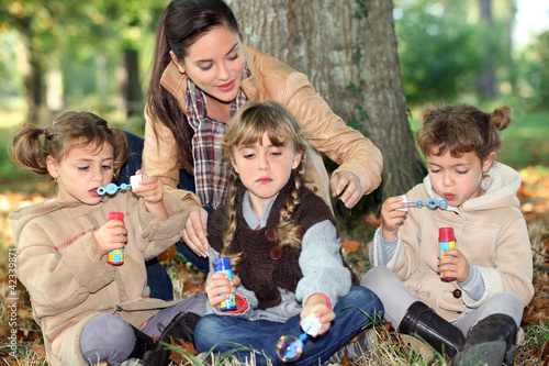 Foto: three little girls making bubbles in the forest three little girls making bubbles in the forest