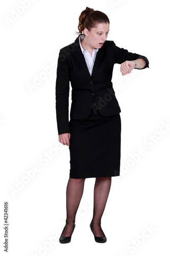 Photo: Elegant woman looking at her watch surprisingly Elegant woman looking at her watch surprisingly