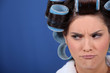 Unhappy woman with hairroller on.