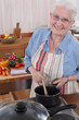 Elderly woman cooking in her kitchen