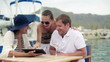 Video: Young ritch friends with tablet computer sitting in marina Young ritch friends with tablet computer sitting in marina