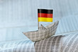 Foto: Papierschiff mit deutscher Flagge auf Börsennachrichten Papierschiff mit deutscher Flagge auf Börsennachrichten