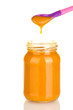Jar with baby food and spoon on white background close-up