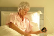 Foto: seniorin im Bett mit Wecker seniorin im Bett mit Wecker