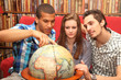 friends planning a journey and looking at a globe