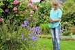 Foto: Frau mit Rosenblüte im Garten Frau mit Rosenblüte im Garten