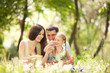 Happy mother, father and daughter playing in the park