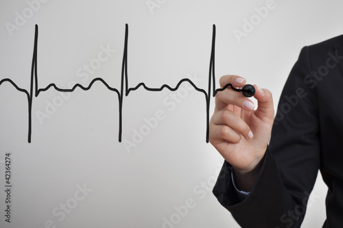 Foto: Business woman drawing heartbeat with black marker Business woman drawing heartbeat with black marker