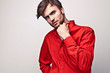 Elegant young handsome man pose on red shirt.