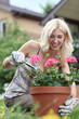 Portrait of a beautiful blonde with a pot of flowers