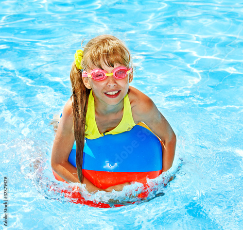 Photo: Child sitting on inflatable ring in swimming pool. Child sitting on inflatable ring in swimming pool.
