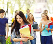 Group student with notebook on bench outdoor.