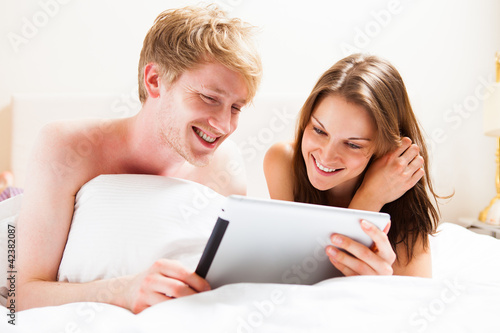 Foto: glückliches Päarchen beim surfen im Bett glückliches Päarchen beim surfen im Bett