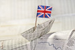 Foto: Papierschiff mit britischer Flagge auf Börsennachrichten Papierschiff mit britischer Flagge auf Börsennachrichten