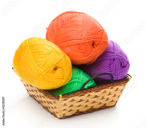 Foto: four yarn skeins in yellow, orange, green, purple colors in bask four yarn skeins in yellow, orange, green, purple colors in bask