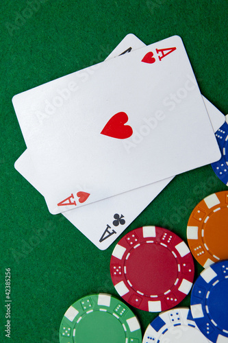Photo: Texas holdem pocket aces on casino table with copy space and chi Texas holdem pocket aces on casino table with copy space and chi