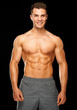 Portrait of muscular sporty man standing on black