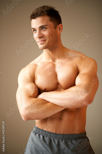 Foto: Smiling handsome man with muscular arms crossed Smiling handsome man with muscular arms crossed