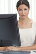 Hispanic Latina Woman or Businesswoman in Office Using Computer