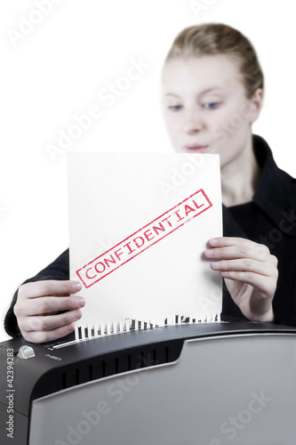 Photo: woman shredding a confidential paper woman shredding a confidential paper