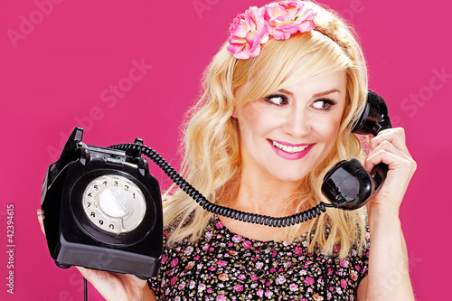 Foto: Woman talking on old telephone Woman talking on old telephone