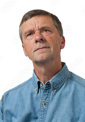 Photo: Senior man in blue shirt looks pensive Senior man in blue shirt looks pensive