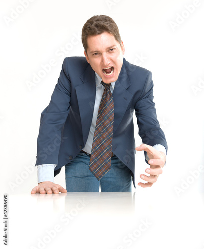 Foto: Angry businessman leaning on a desk Angry businessman leaning on a desk
