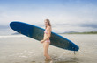 Young woman with surfboard on beach