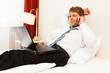 Geschäftsmann mit Computer und Telefon im Hotel