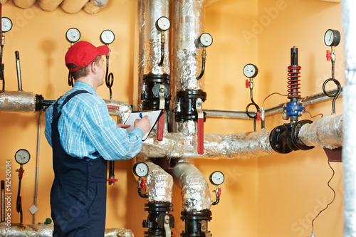 Photo: heating engineer repairman in boiler room heating engineer repairman in boiler room