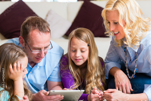 Foto: Family playing with Tablet computer at home Family playing with Tablet computer at home