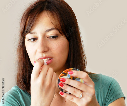 Photo: Young woman applying makeup Young woman applying makeup