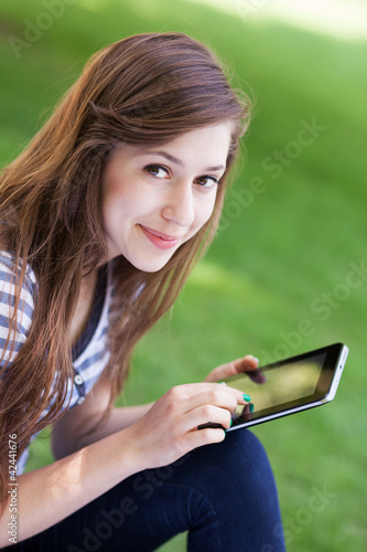 Photo: Woman using digital tablet outdoors Woman using digital tablet outdoors