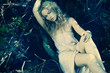 beautiful blond girl in a wet white dress in wild wood