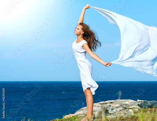 Photo: Freedom Concept. Girl with White Scarf standing on the Rock Freedom Concept. Girl with White Scarf standing on the Rock