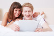 Paar schaut Film auf Tablet Computer im Bett
