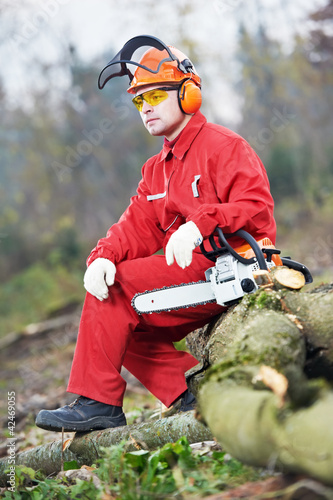 Foto: Lumberjack Worker With Chainsaw In The Forest Lumberjack Worker With Chainsaw In The Forest
