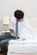 Mann liest Zeitug am Bett