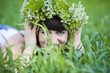 beautiful girl in wreath of flowers lay in meadow on sunny day