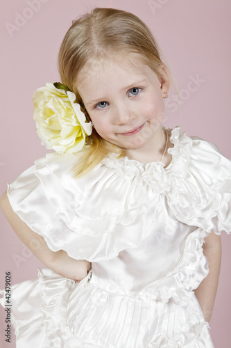 Photo: Portrait of the child in a white dress with a flower Portrait of the child in a white dress with a flower