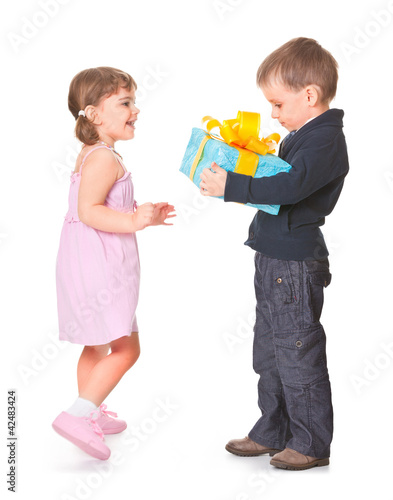 Photo: Little boy giving a gift box to her girlfriend Little boy giving a gift box to her girlfriend